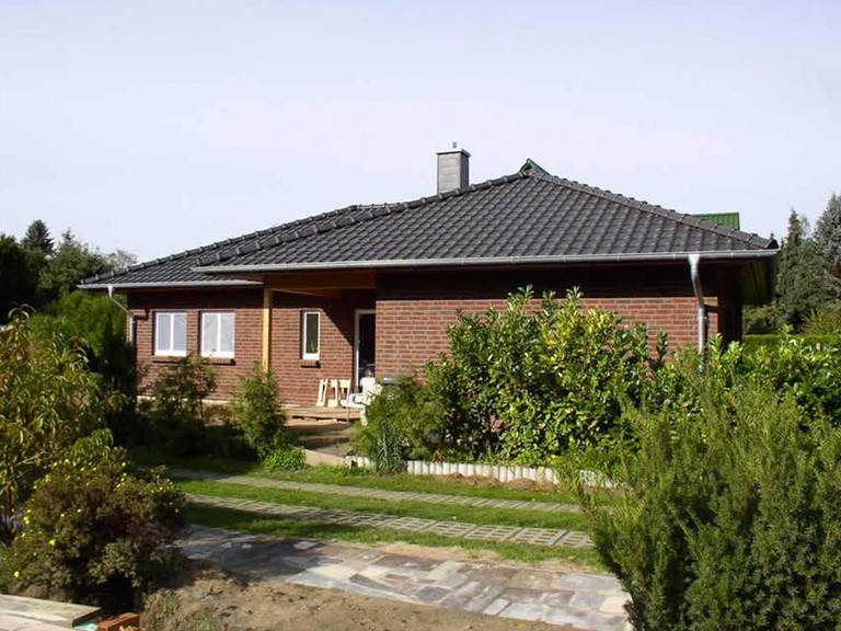 Aussenansicht auf die teilweise überdachte Terrasse des Winkelbungalows mit Verblendfassade.