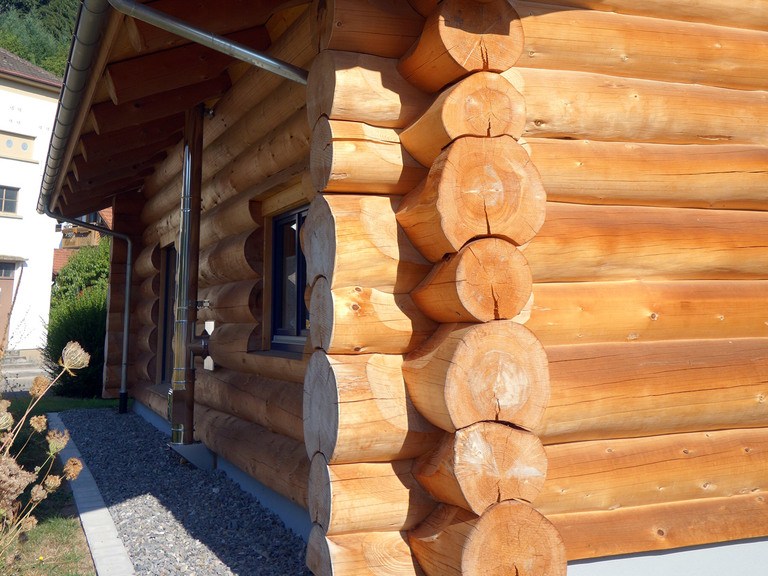 Einstöckiges Naturstammhaus mit Carport BlockHausBau