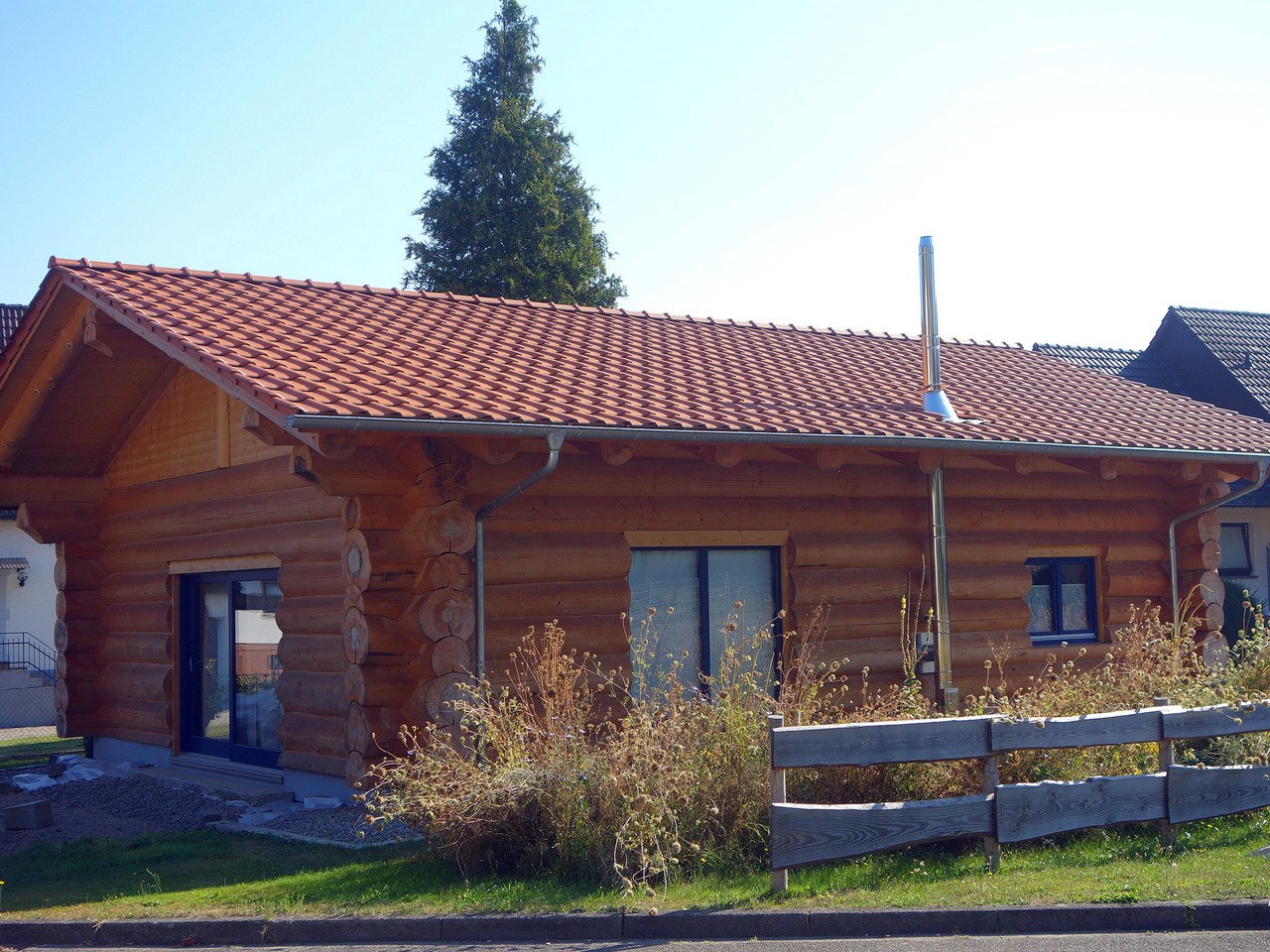 Einstöckiges Naturstammhaus mit Carport - BlockHausBau | Musterhaus.net